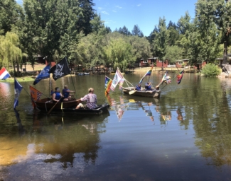 Teens row boats on Lake Lakoya at Enchanted Hills Camp
