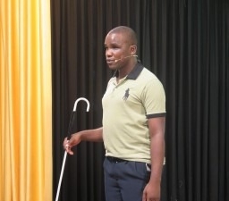 Robert-Malunda Robert Malunda standing with a white cane in his hand