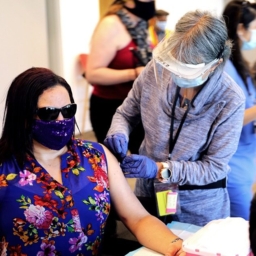 A nurse preps a person to receive a COVID-19 shot at LightHouse in 2021