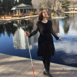 Leona Godin Dr. M. Leona Godin stands on a dock holding her white cane