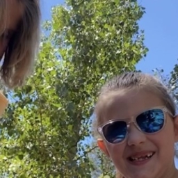 Enchanted Hills Camp counselor, Hannah, holds camper Martie’s hand while counselor Alena sits behind them at EHC Family Camp summer 2022