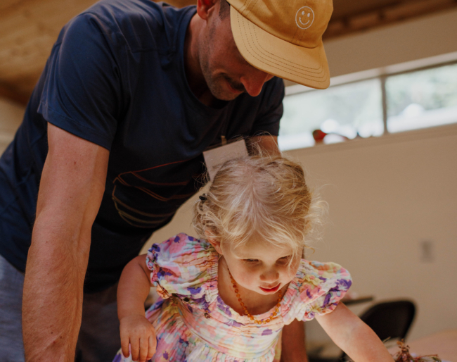 Hunter looks on as his Little Learner plays with a lightboard with tiles