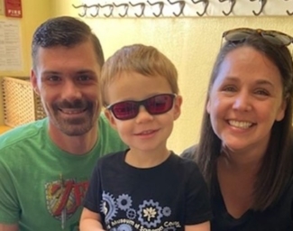 Dad, Little Learner and Amy kneel for a photo. Little Learner wears sunglasses