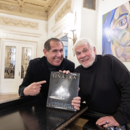 Alex and Steve smile and hold the book, Frank Sinatra: An American Legend by Nancy Sinatra. 