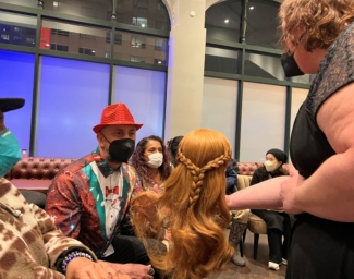 LightHouse student Carol touches a wig used in FROZEN the musical