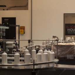 A shot of the manufacturing floor inside the LightHouse Sirkin Center, an employee with a white cane can be seen in the background