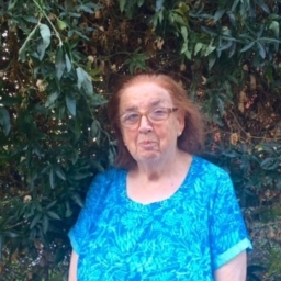 In front of a wall of leaves and flowers