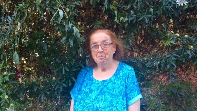 In front of a wall of leaves and flowers