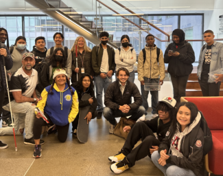 Latitude students and instructor pose with LightHouse community members and staff in front of the 10th floor staircase at LightHouse in 2023.
