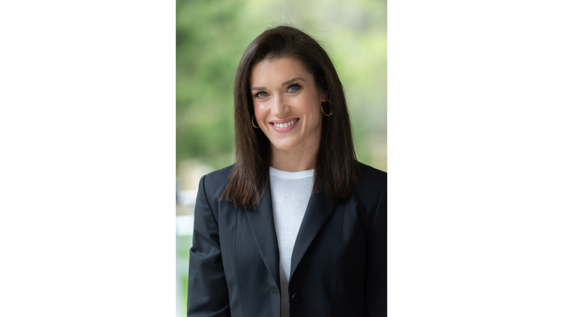 Rebecca Alexander is a woman with dark brown shoulder length hair and is wearing a white blouse under a black blazer.