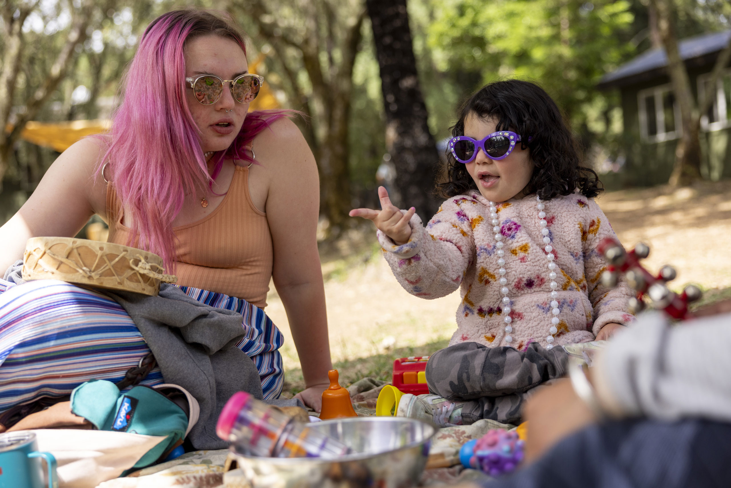 EHC Assistant Camp Director Ellie Kneer and a little learner play with sound makers and sensory toys.