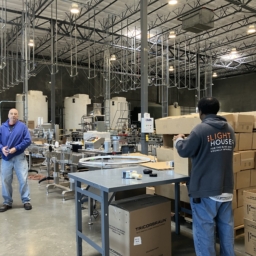 Sirkin Center floor Chris Peterson LightHouse Sirkin Center employee, Chris Peterson, stands on the manufacturing floor holding a bottled cleaning product while another employee wearing a LightHouse sweatshirt packages bottled products fresh off the manufacturing line for shipment.