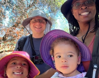 Little Learner Casey, Little Learner Mom Latasha and family smile while wearing sunhats in various colors