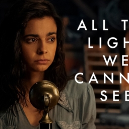 Netflix All the Light Marie-Laure A teenage girl, Marie-Laure Leblanc, sits in front of a old time radio microphone