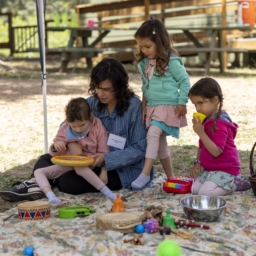 Little Learers and a parent playing on a blanket at Little Learners Family Camp