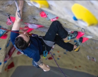 Image looking down on Andrew climbing up a paraclimbing rock wall