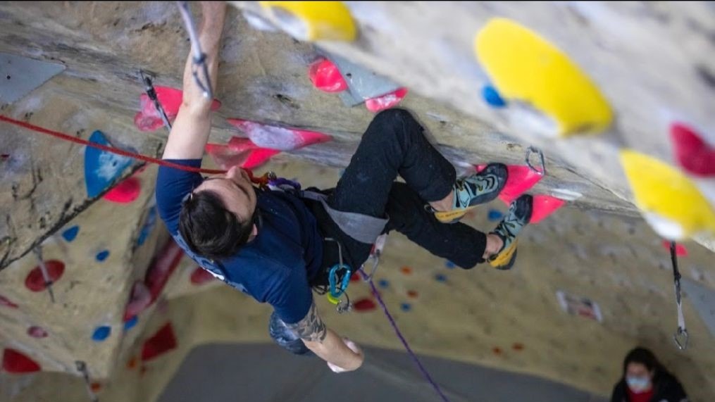 Image looking down on Andrew climbing up a paraclimbing rock wall