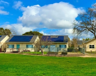 EBC Campus - Four class-room sized yellow buildings surrounded by grass, greenery, and trees