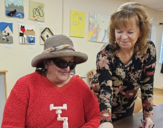 Cathy, right, stands and smiles as she watches a client