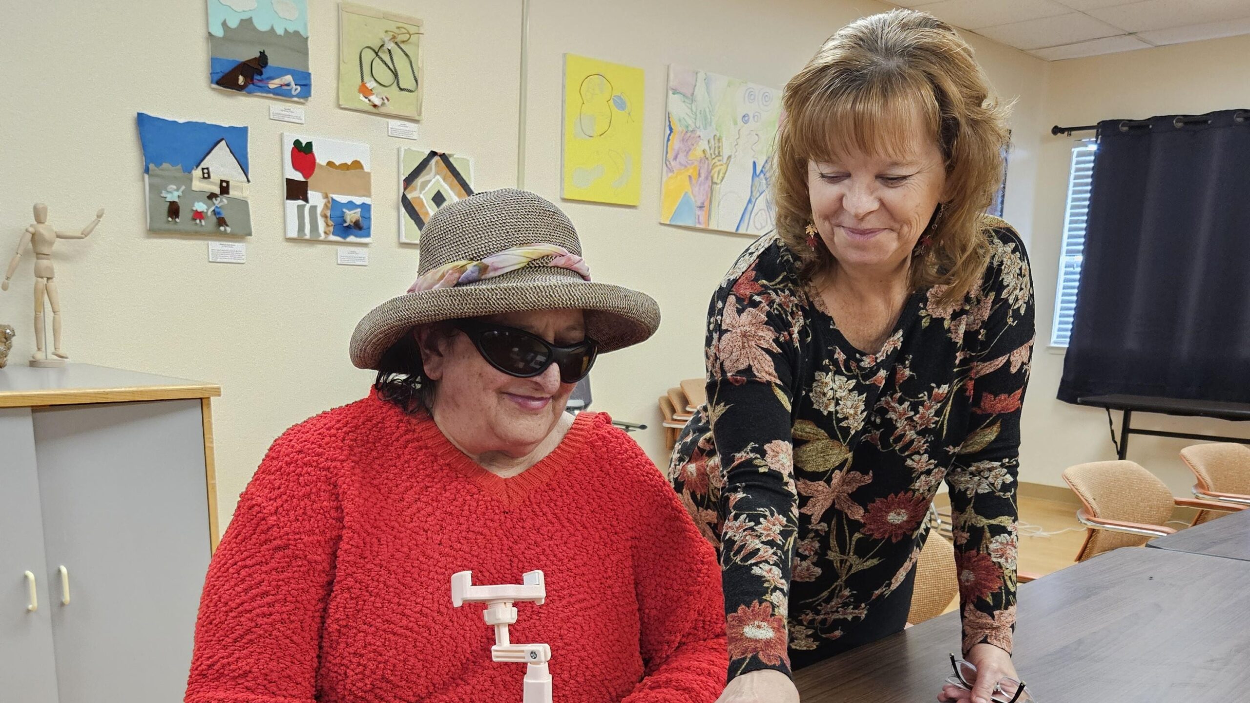 Cathy, right, stands and smiles as she watches a client