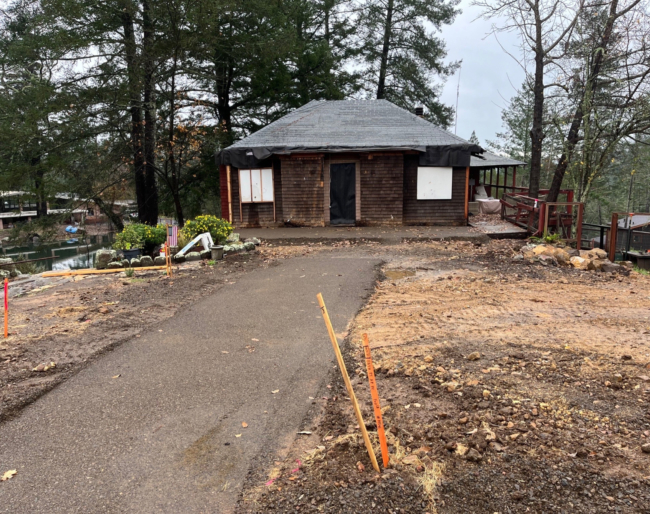 Restoration of the Gathering House, a single-story structure surrounded by trees and greenery